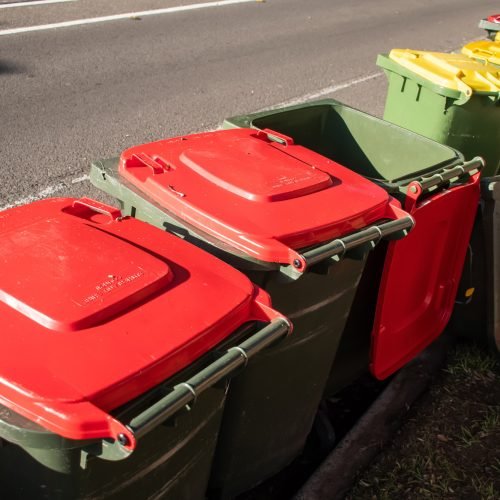 Wheelie bins for household rubbish garbage waste lined up on the street after council collection